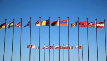 Die Vielfalt bei einer Internationale Kundenbefragung ist durch verschiedene Flaggen zu sehen, die an Masten hängen.